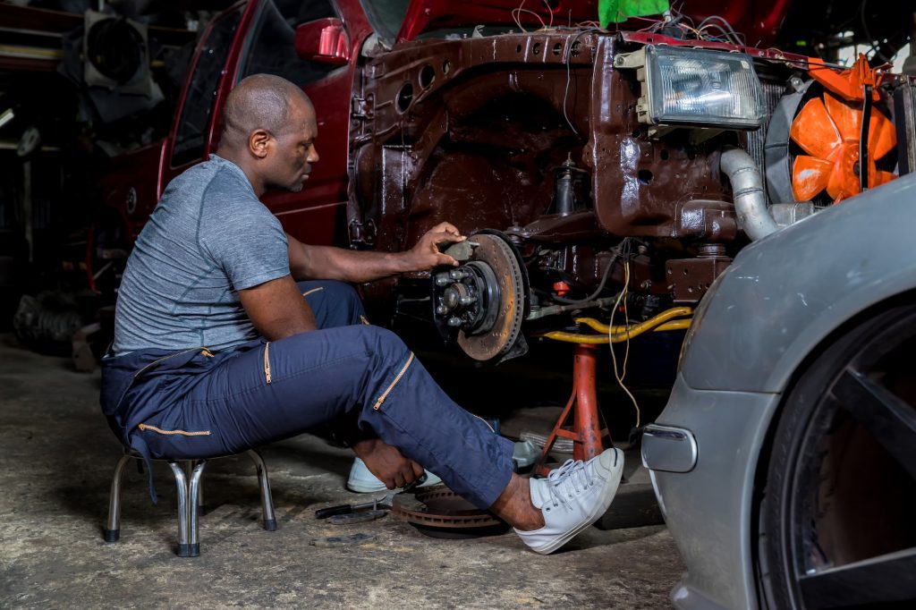 Mechanic checking and replacement of ventilated automobile brake discs.