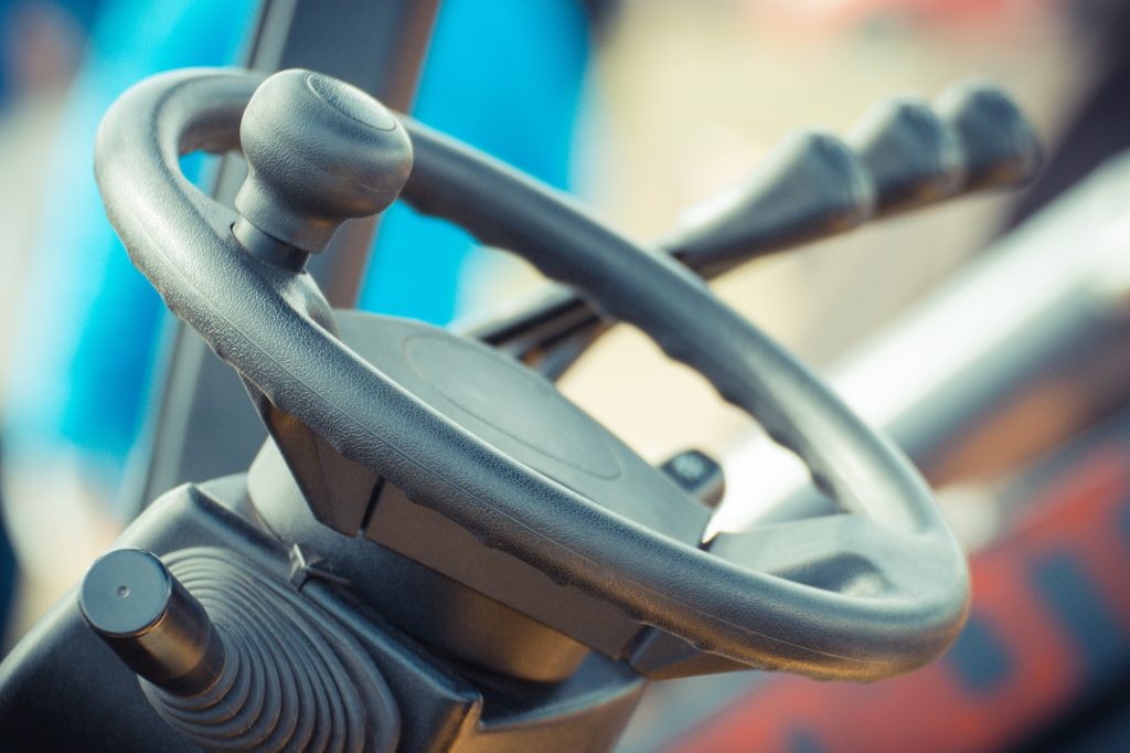 Steering wheel and operating control levers in forklift, tractor or other industrial machine